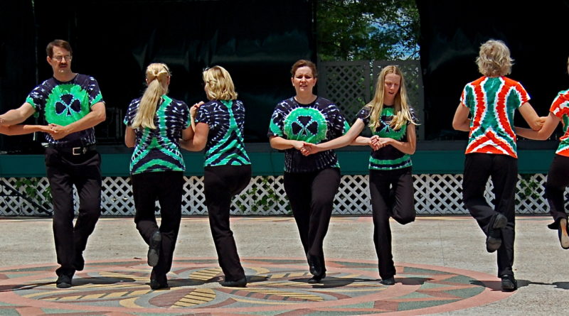 Picture, Men and women on stage, wearing tie-dyed shirts and Irish dancing in
